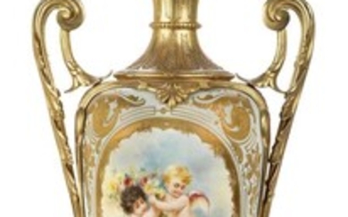A French gilt-metal mounted Sevres-style porcelain lamp, first half 20th century, with foliate twin handles, the tapering body decorated with two winged putti holding flowers, the onyx base with chamfered corners on paw feet, 53cm high excluding...