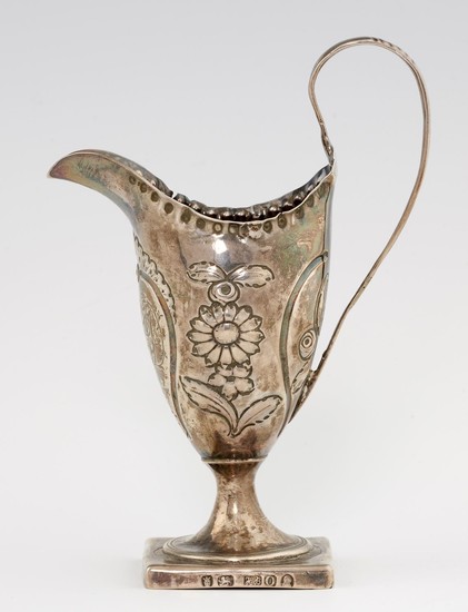 A GEORGE III HELMET SHAPED SILVER CREAM JUG chased with a su...