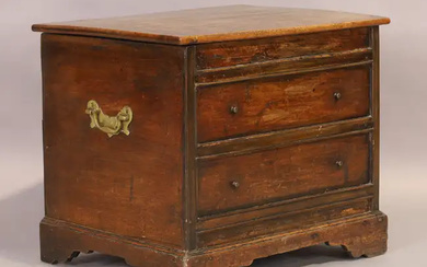 A George II walnut commode, second quarter 18th century, the hinged top...