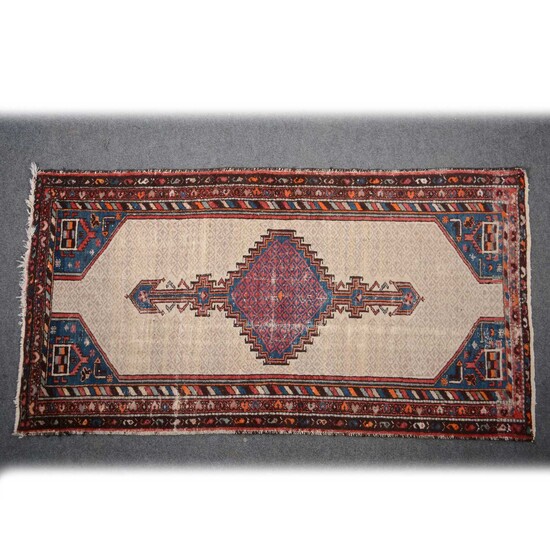 A Persian rug, red and blue central stepped medallion on a pole