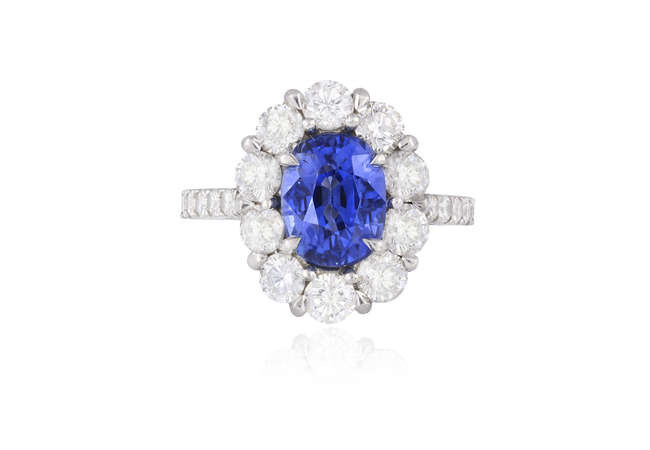 A SAPPHIRE AND DIAMOND CLUSTER RING The oval-shaped...