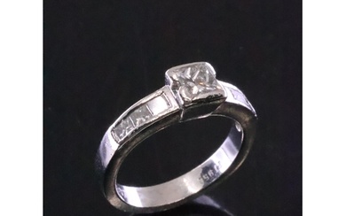 A diamond solitaire ring set with diamond shoulders with a c...