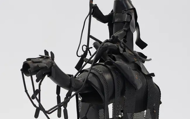 A metal sculpture of an Arab soldier with rifle riding a camel,...