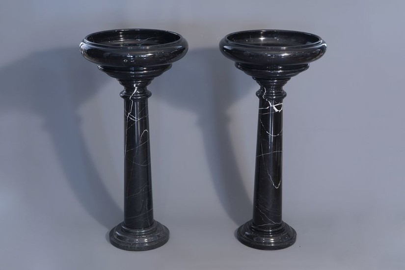 A pair of black gray marble pedestals with...