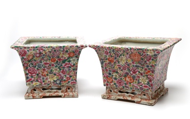 A pair of polychrome porcelain planters, each painted with blossoming flowers on a white ground