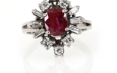 A ruby and diamond ring set with an oval-cut treated ruby encircled...