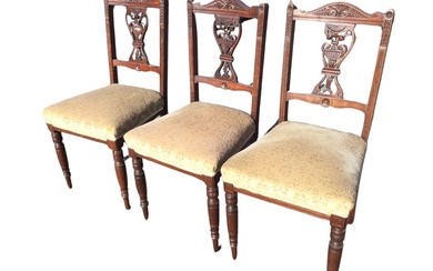 A set of three Edwardian mahogany chairs with carved arched...