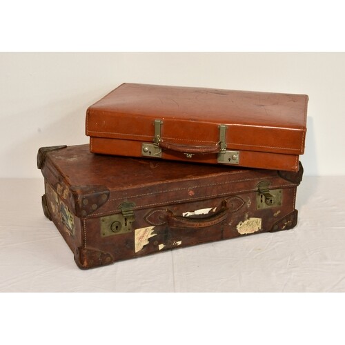 A vintage brown leather suitcase, together with a further su...