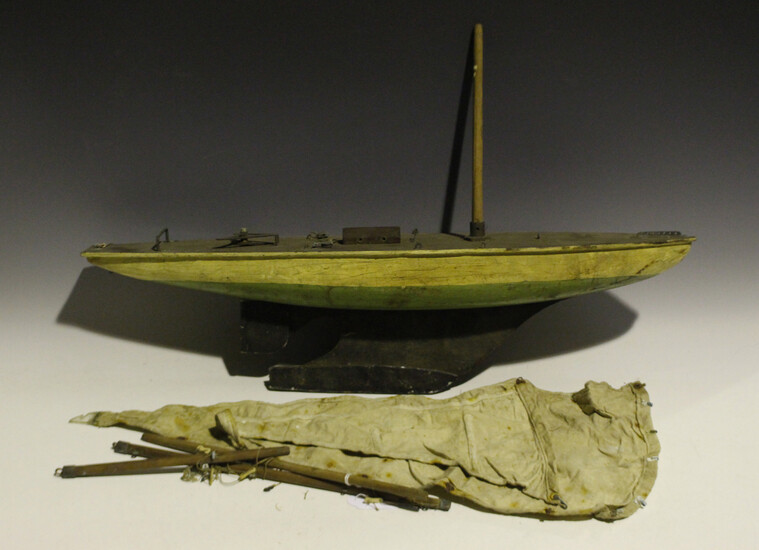 An early/mid-20th century wooden pond yacht with cloth sails, faux wooden deck, cream and green pain
