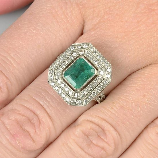 An emerald and diamond cluster ring. Emerald calculated