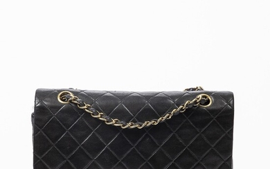 NOT SOLD. Chanel: A "Classic Double Flap" bag made of black leather with gold toned...