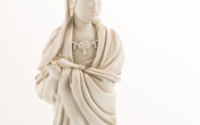 Guanyin en porcelaine émaillée blanc, représentée debout sur des nuées d'où émerge un dragon. Chine,...