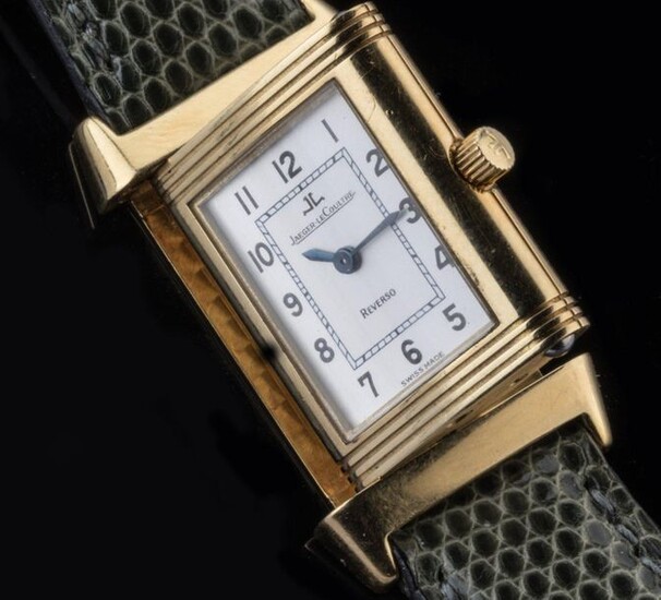 JAEGER-LECOULTRE. WATCH BRACELET model REVERSO LADY. Ladies' watch in yellow gold 750 thousandths. The reversible case reveals a white enamelled dial showing the hours in Arabic numerals around a railway. Blued steel sword hands. The inside of the...