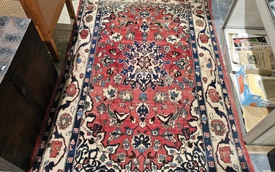 Large red ground rug with central floral medallion on floral...