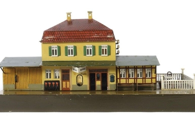 Märklin rural railway station, gauge 0, model 2031/0, BZ 1919-1925, painted. Sheet metal construction, attached goods shed and bus stop shelter in half-timbered style, with tables, chairs and fencing on one side, triangular station sign stuck on the...