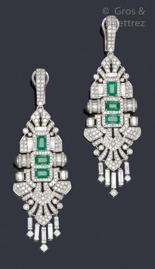 Pair of white gold earrings decorated with openwork scrolls and palmettes entirely set with brilliant-cut diamonds and baguette-cut diamonds set with three rectangular cut-faceted emeralds and cabochon emeralds. In the Art Deco taste. Longueur : 7,2...