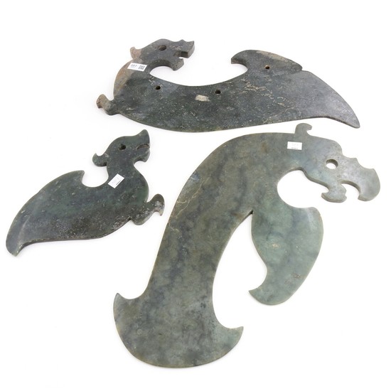 Three Chinese ornaments of green jade, carved in the shape of dragons. Weight app. 5650 g. L. 33–52 cm. (3)