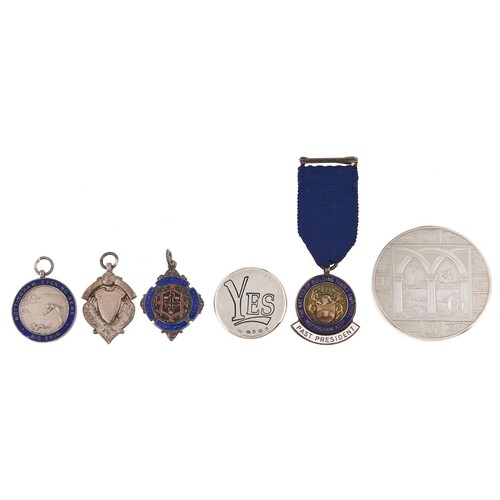 Three silver watch fob medallions, a similar badge, a commem...