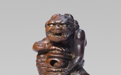 A rare and interesting wood netsuke of an oni with a reliquary, by Awataguchi. First half 19th century