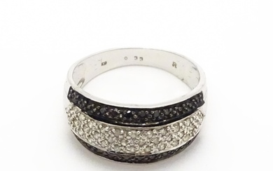 A 9ct white gold ring set with banded white and black diamon...