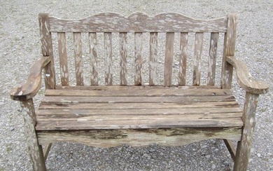 A Bridgman two seat weathered teak garden bench with slatted...