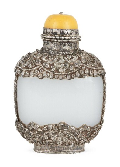 A Chinese white metal encased glass snuff bottle, early 20th century, the white metal case repousse decorated with floral motifs, yellow hardstone stopper, 9.5cm high