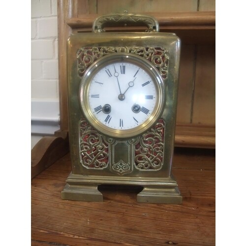 A French brass mantel clock, with scrolled and pierced decor...