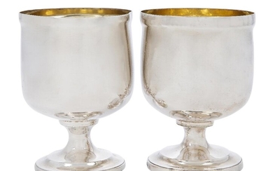 A George III silver double-cup, London 1807 and 1808, William Burwash and Richard Sibley, each goblet of rounded form and raised on a spreading circular foot, the feet designed to fit together and the interiors with gilt wash, 11.1cm high, total...
