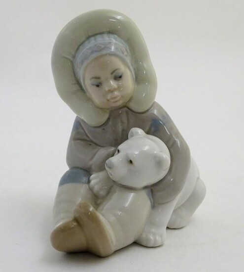 A Lladro figure of an Eskimo girl with a polar bear