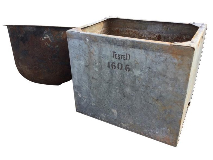 A basin shaped cast iron boiling pot with flat...