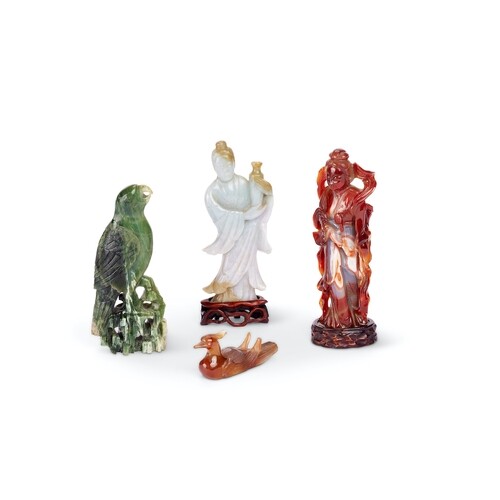 A celadon jade figure of a deity and three other figures The...