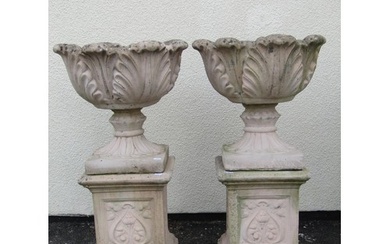 A pair of cast composition stone garden urns with circular a...