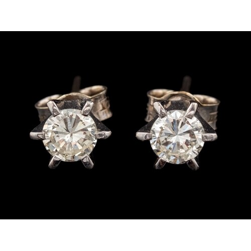 A pair of diamond ear studs,: each set with a brilliant cut ...