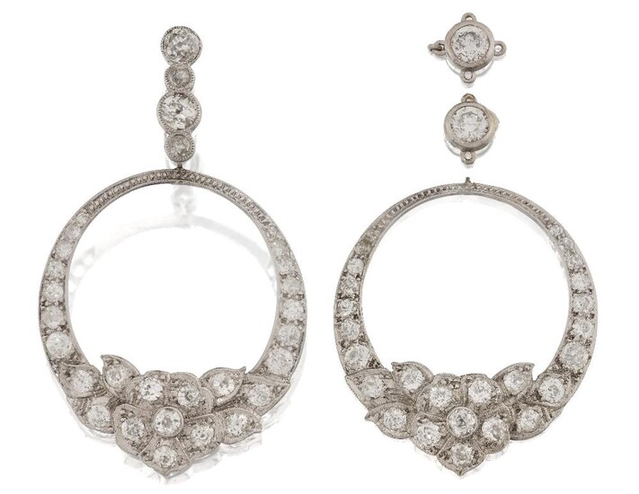 A pair of early 20th century white gold, diamond hoop earrings, each designed as an old-brilliant-cut diamond graduated hoop with central diamond foliate cluster motif to a diamond three stone suspension loop (loop deficient on one earring but...