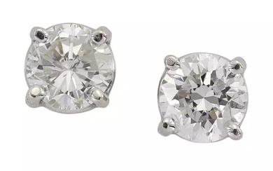 A pair of single stone diamond stud earrings, each with a brilliant-cut diamond, with a total...
