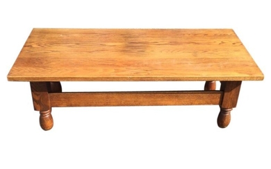 A solid oak coffee table, the rectangular top on...