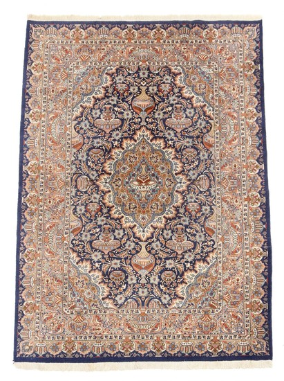 An Indian carpet, classic medallion design with vases, ornaments, flowers and foliage on blue base. 20th century. 334×245 cm.