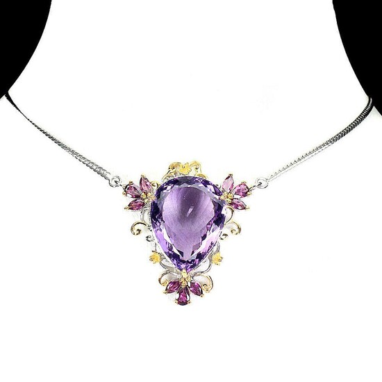 SOLD. An amethyst necklace set with an oval-cut amethyst and numerous circular-cut rhodolite garnets, mounted in rhodium and gold plated sterling silver. L. 50 cm. – Bruun Rasmussen Auctioneers of Fine Art