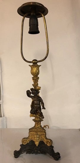 An early 20th century French gilt bronze table lamp shaped as a putto. H. including shade holder 54 cm.