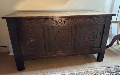 Antique oak coffer, earlier elements, with carved three panelled front, on black feet, 113cm wide x 51cm deep x 61cm high