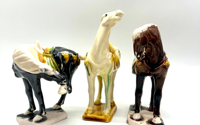 CHINESE MASTERPIECES: THREE ANCIENT WAR HORSES MADE OF GLAZED PORCELAIN IN THE STYLE OF THE TANG DYNASTY.