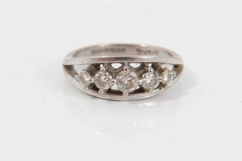 Diamond five stone ring with five graduated brilliant cut diamonds in claw setting within a white gold border on plain shank. Signed 'Starlight', hallmarked Birmingham 1994, ring size Q½. Estimated...