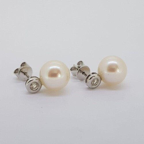 White gold bezel set diamond and freshwater pearl earrings. ...