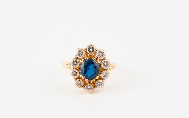 Yellow gold (750) daisy ring centered on an oval faceted sapphire, surrounded and shouldered by brilliant-cut diamonds, in claw or grain settings.