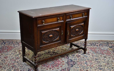 A 1920's oak sideboard, with two drawers above two cupboard...