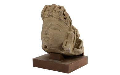 A BUFF SANDSTONE HEAD OF A GODDESS OR APSARA Madhya Pradesh, India, Chandella period, 10th - 12th century