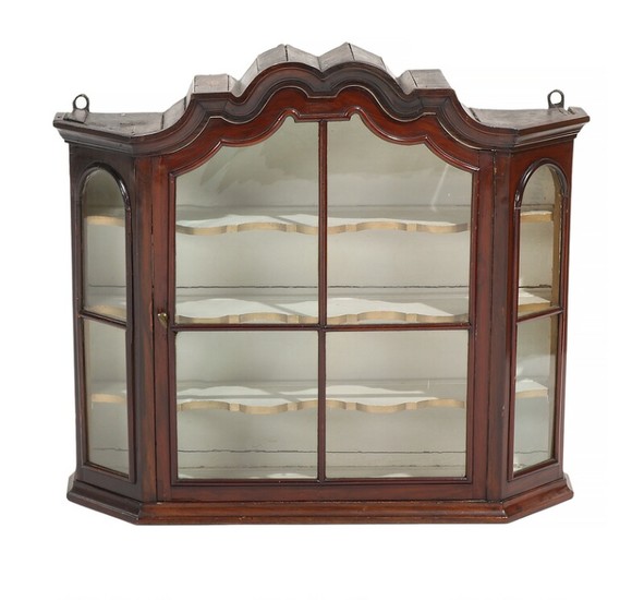 A Baroque walnut wall display cabinet, curved top, front with glass door. 18th-19th century. H. 63. W. 72. D. 20 cm.