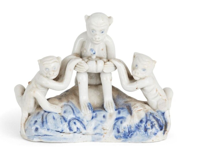 A Chinese Dehua porcelain 'monkeys' figure group, early 19th century, depicting three monkeys sat atop a rocky outcrop splashed with blue glaze, the central monkey holding a pumpkin, 8cm long