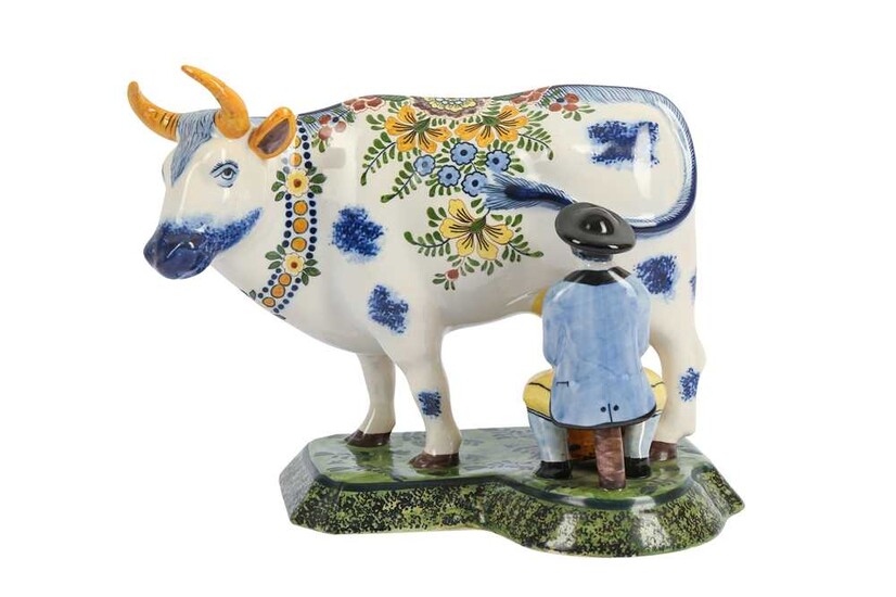 A DUTCH DELFT POTTERY FIGURE OF A MAN AND A COW, 20TH CENTURY