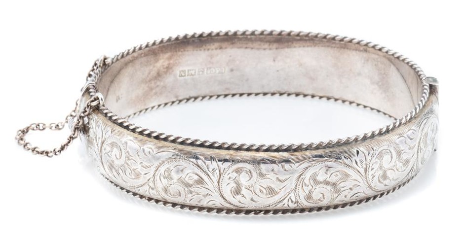 A HALLMARKED STERLING SILVER HINGED BANGLE; 1.5cm wide hollow bangle with engraved scrolling decoration to front and applied wire tw...